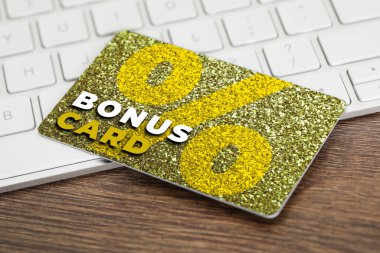 Şık tasarımı olan bonus kart ve ahşap masada bilgisayar klavyesi
