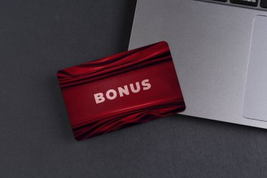 Gri masada şık tasarım ve dizüstü bilgisayarı olan bonus kart.