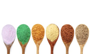 Beyaz arka planda kaşıklarda farklı süper yiyecek tozları, kolaj. Üst görünüm