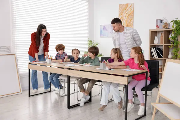 Öğretmenleri evde resim dersinde olan çocuklar. Çizim yapmayı öğrenmek