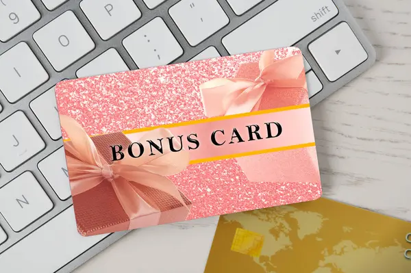 Beyaz ahşap masa üzerinde şık tasarım ve bilgisayar klavyeli bonus kart, üst görünüm