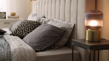 Odasında yumuşak çarşaflar ve battaniyeler olan rahat bir yatak, sola hareket eden kamera. Ev tekstili