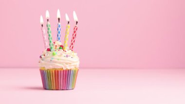 Mumları kekin içinde yakmak ve pembe arka planda serpiştirmek, metin için boşluk