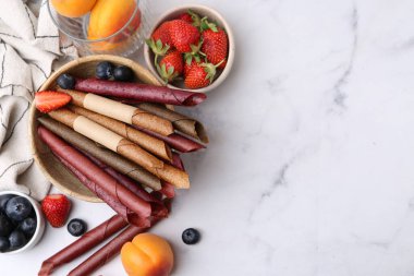 Lezzetli meyve dürümleri, kayısılar ve böğürtlenler beyaz mermer masada, düz bir şekilde. Metin için boşluk