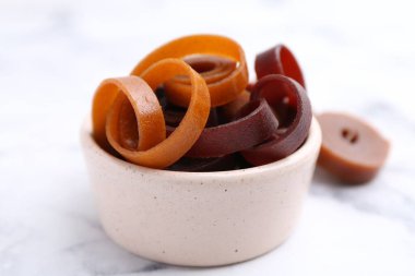 Lezzetli meyve derisi yuvarlanır beyaz mermer masada, yakın plan