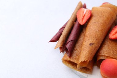 Lezzetli meyve dürümleri, çilek ve kayısı ışıklı masada, yakın plan. Metin için boşluk