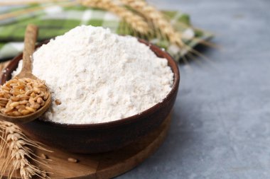 Buğday unu kasede, tahıllar ve çiviler gri masada, yakın plan. Metin için boşluk