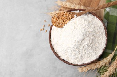 Buğday unu kasede, tahıllar ve çiviler gri masada, düz yerde. Metin için boşluk