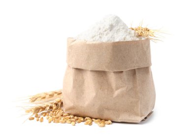 Kese kağıdında buğday unu, beyaz arka planda tahıl ve çiviler.
