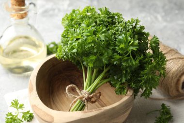 Taze maydanoz, yağ ve iplik gri desenli masa, yakın plan.