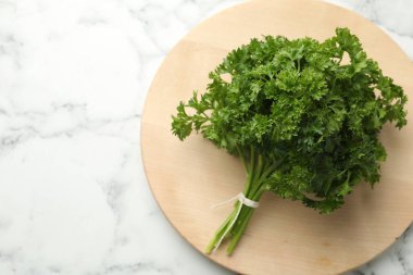 Beyaz mermer masada bir demet taze maydanoz, üst manzara. Metin için boşluk