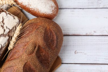 Taze ekmek somunları ve beyaz ahşap masada çiviler düz yerde. Metin için boşluk