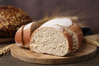 Taze kesilmiş ekmek ve çiviler ahşap masada, yakın plan.