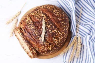 Taze pişmiş somun ekmek, yulaf lapası ve çivili, düz bir masa.