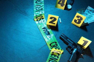 Adli tıp uzmanlığı. Deliller, işaretler ve mavi arka planda polis bandı olan bir suç mahalli. Renkli tonlama efekti