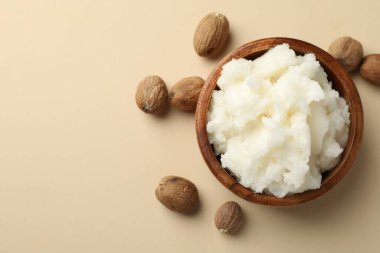 Doğal Shea tereyağı ve fındıklar bej arka planda, düz. Metin için boşluk