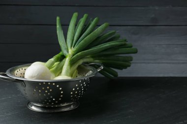 Siyah masada taze taze taze taze soğan kevgir.