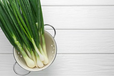 Beyaz ahşap masada taze taze taze taze soğan, üst manzara. Metin için boşluk