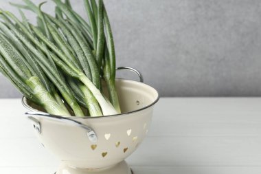 Beyaz ahşap masada taze taze taze taze soğan. Metin için boşluk