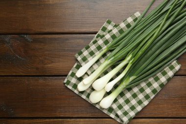 Taze taze taze soğan ve ahşap masa üzerinde havlu, üst manzara. Metin için boşluk