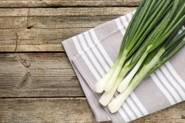 Taze taze taze soğan ve ahşap masa üzerinde havlu, üst manzara. Metin için boşluk