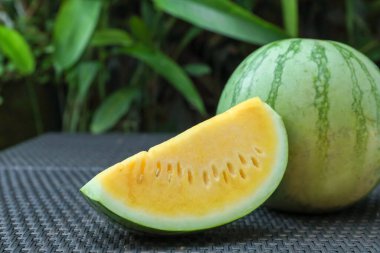 Açık havada hasır masada sarı karpuzlar var, yakın plan.