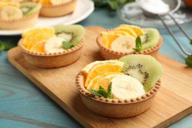 Meyveli tart ve açık mavi ahşap masada nane şekeri, yakın plan. Tatlı nefis.