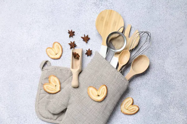 Farklı mutfak aletleri fırın eldiveni, kurabiye ve anason yıldızları ışık masasında, düz yatıyordu.