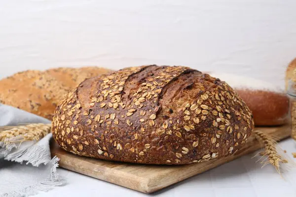 Taze ekmek somunları ve çiviler beyaz fayanslı masada, yakın plan.