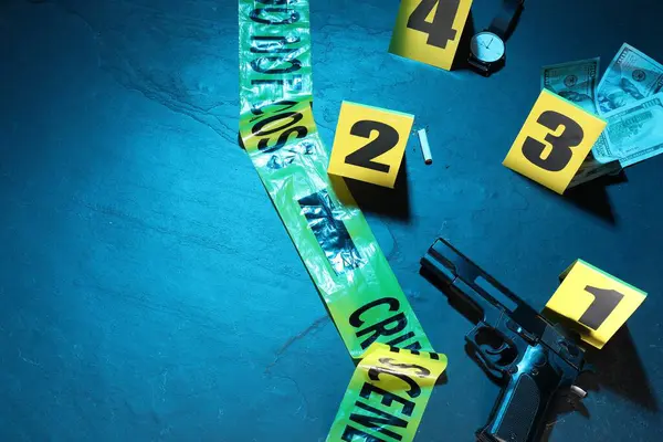 Adli tıp uzmanlığı. Deliller, işaretler ve mavi arka planda polis bandı olan bir suç mahalli. Renkli tonlama efekti