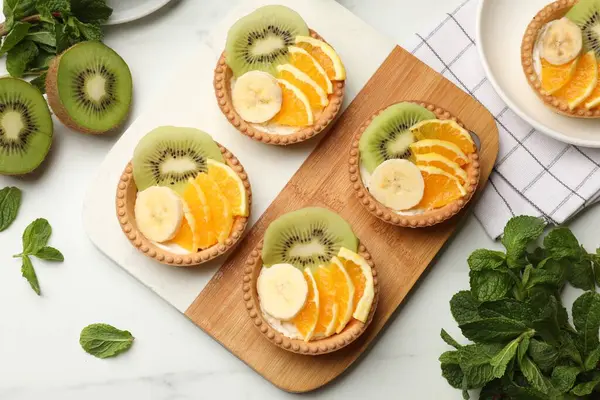 Meyveli tart ve nane şekerli beyaz masa, düz. Tatlı nefis.