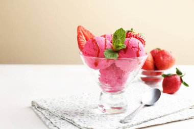 Şerbeti şerbetle, çilekle ve nane şekeriyle bej arka planda beyaz masada, yakın plan. Metin için boşluk