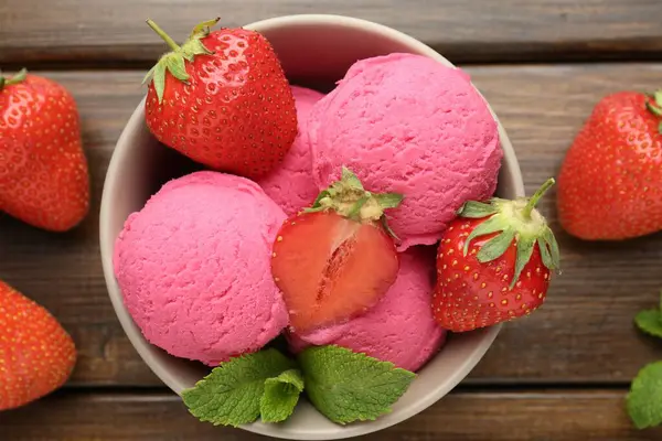 Çilekli şerbet ve ahşap masada servis edilen nane şekeri.