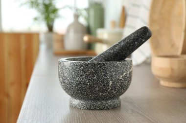 Mutfaktaki ahşap masada taş havan ve tokmak.