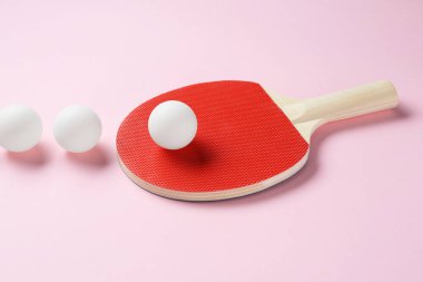 Pembe arka planda pinpon raketi ve topları.