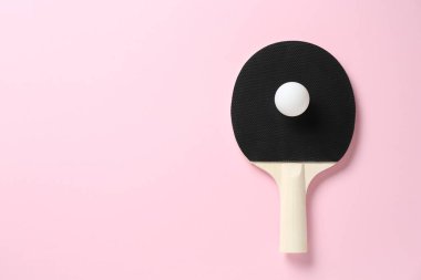 Pembe arka planda pinpon raketi ve top, üst manzara. Metin için boşluk