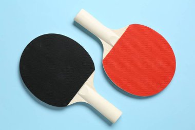 Açık mavi zemin üzerinde pinpon raketleri, düz yatıyordu