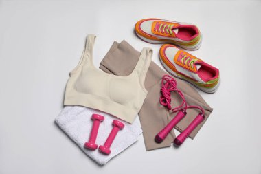 Spor kıyafetleri, halterler, spor ayakkabıları, havlular ve beyaz arka planda ip atlama, düz yatış.