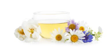 Cam bardakta aromatik bitki çayı ve beyaz bardakta izole edilmiş çiçekler.