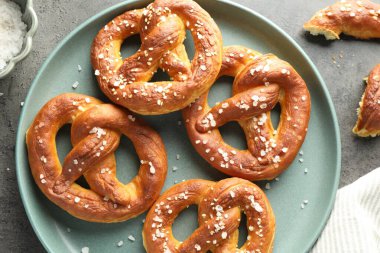 Gri masadaki tuzlu krakerler, düz.