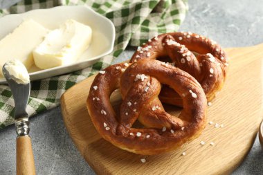 Açık gri masada tuz ve tereyağlı lezzetli krakerler, yakın plan.