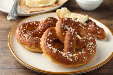 Ahşap masada tuz ve tereyağlı lezzetli krakerler, yakın plan.