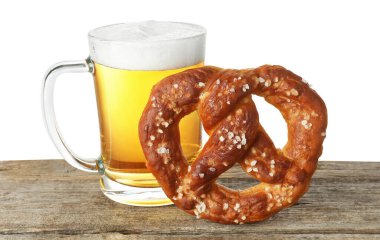 Lezzetli kraker ve bir bardak bira beyaz arka plana karşı ahşap masada.