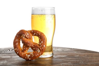 Lezzetli kraker ve bir bardak bira beyaz arka plana karşı ahşap masada.