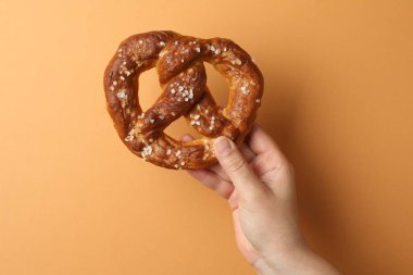 Turuncu arka planda lezzetli krakerli kadın, yakın plan.