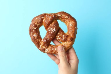 Açık mavi arka planda lezzetli krakerli kadın, yakın plan.