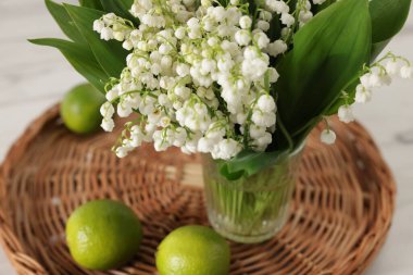 Güzel bir zambak buketi ve limonlar beyaz masada, yakın plan.