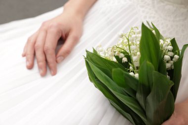 İçinde güzel vadi zambakları olan gelin, yakın plan.