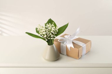 Vadi çiçeklerinin güzel zambakları ve beyaz masada hediyeler.