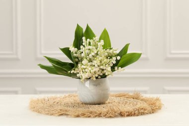 Vadi çiçeklerinin güzel zambakları beyaz masadaki vazoda.